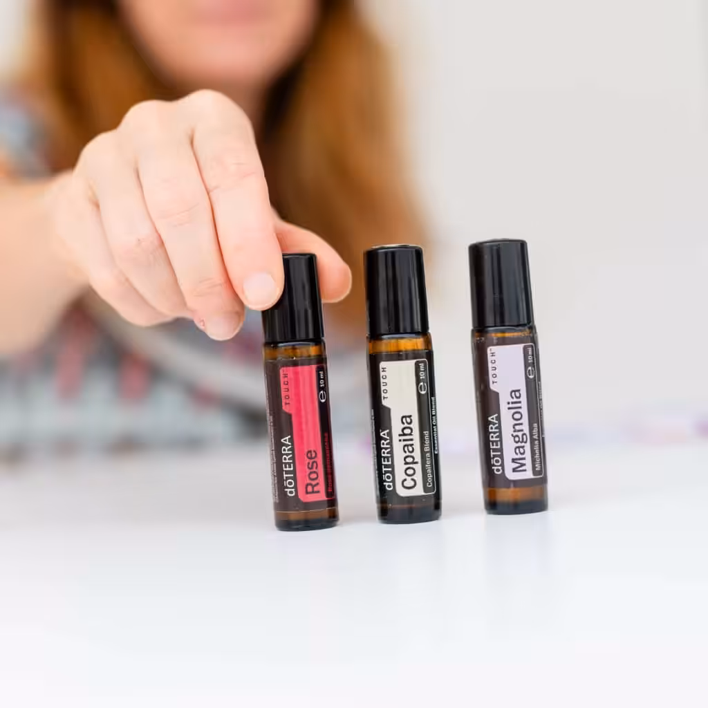 Lernen mit Leichtigkeit: drei Roll Ons (Rose, Copaiba, Magnolia) stehen auf einem Weißen Tisch nebeneinander